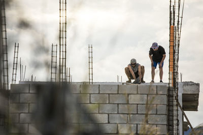 Low angle view of construction workers on roof.