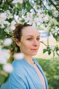 Portrait of young woman against plants