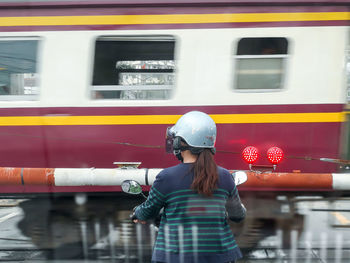 Woman standing by train at railroad station platform