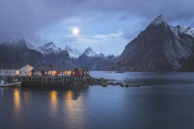 Scenic view of lake by snowcapped mountains against sky