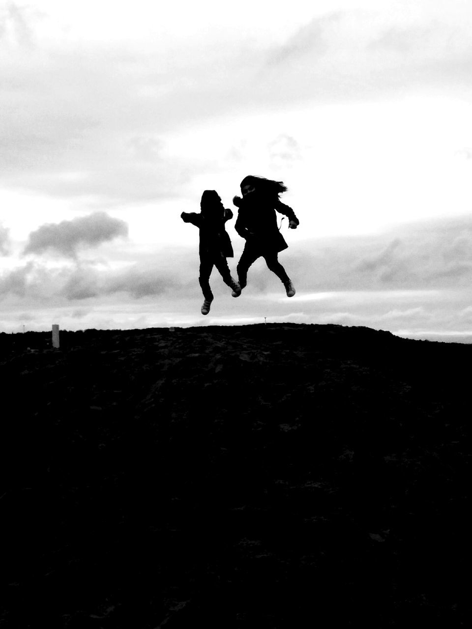 silhouette, lifestyles, full length, leisure activity, sky, men, sea, cloud - sky, standing, jumping, mid-air, horizon over water, person, beach, outdoors, nature, dusk