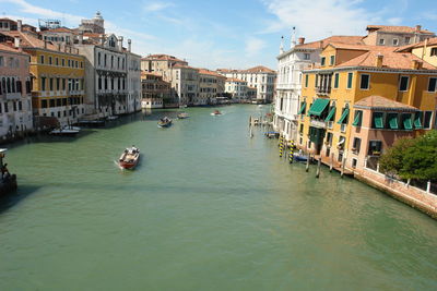 Boats in canal amidst buildings in city