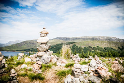 Stack of rocks on mountain against sky