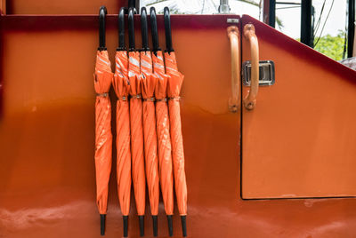 Close-up of pipe hanging against orange wall