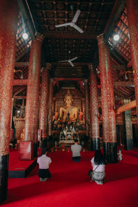 Rear view of people walking in temple building