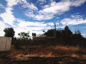 Scenic view of field against cloudy sky