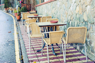 Empty chairs and tables at sidewalk cafe