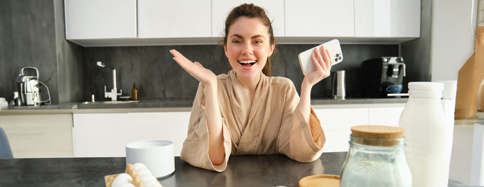 Portrait of young woman drinking coffee at home