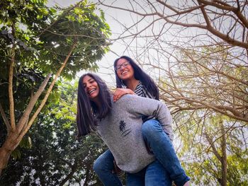 Portrait of siblings against tree