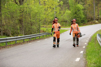 Female lumberjacks walking on forest road