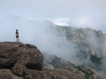 Woman standing on rocky mountain