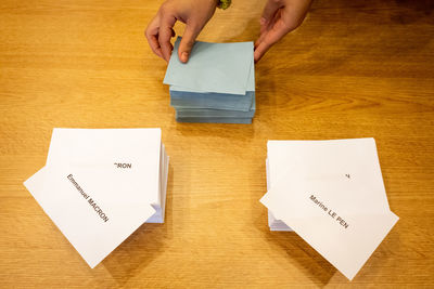 High angle view of man holding paper on table