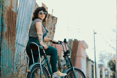 Street portrait of beautiful woman with vintage style riding bicycle
