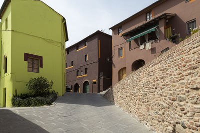 Residential buildings by street against sky