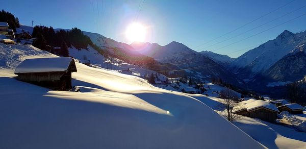 Scenic view of snowcapped mountains against sky on sunny day