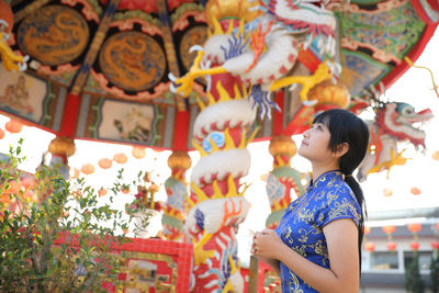 Side view of young woman standing in temple