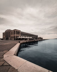 Building by sea against sky