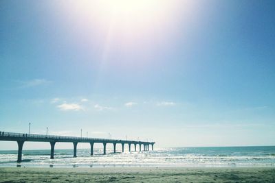 Pier in sea against sky on sunny day