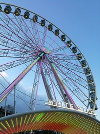 Low angle view of ferris wheel against blue sky