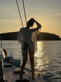 Rear view of man standing against sky during sunset