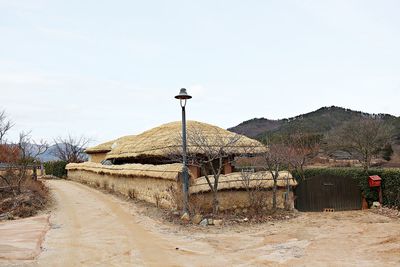 Road by built structures against clear sky