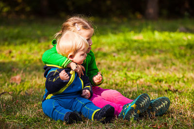 Boy sitting on grass in farm