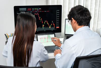 Side view of woman using laptop at table