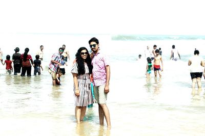 People enjoying at beach against sky