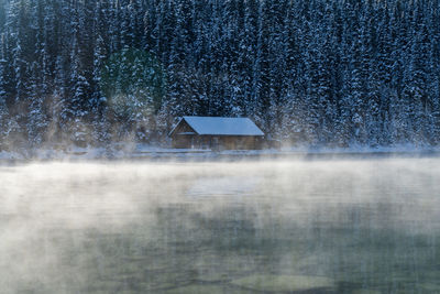 Scenic view of field by building during winter