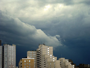 Buildings in city against cloudy sky