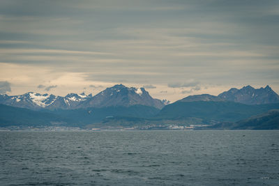 Scenic view of snowcapped mountains by sea against sky