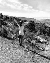 Rear view of young woman against sky