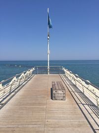 Pier over sea against blue sky