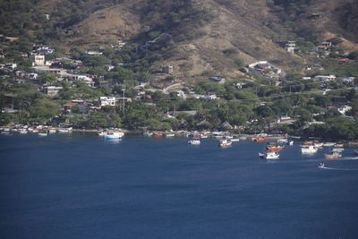 Boats on sea by trees against sky