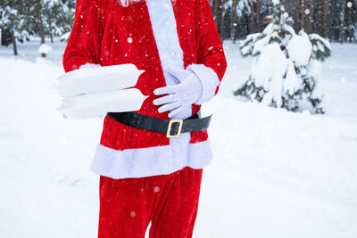 Midsection of woman standing on snow covered field