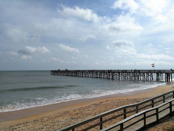 Scenic view of beach and pier against sky