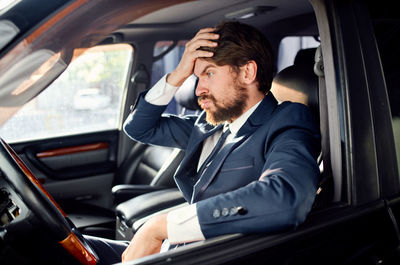 Young man sitting in car