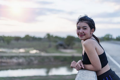 A young woman taking a breath of fresh air after exercising with a smiling face