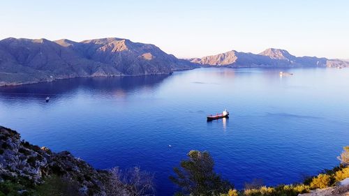 Scenic view of lake and mountains against clear sky