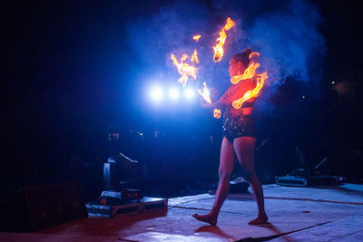 Young woman performing with fire at night