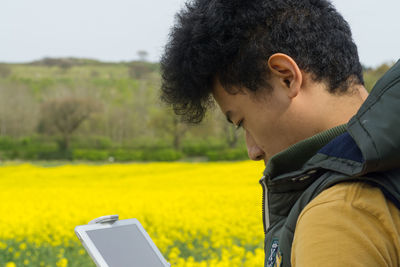 Close-up of man using mobile phone on field