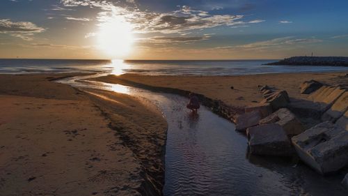 Scenic view of beach against sky during sunset