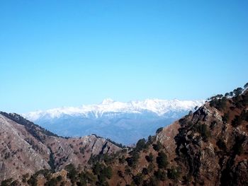 Scenic view of snowcapped mountains against clear blue sky