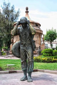 Statue in park against sky