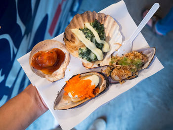 Low section of person holding seafood on paper