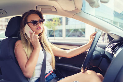 Midsection of woman sitting in car