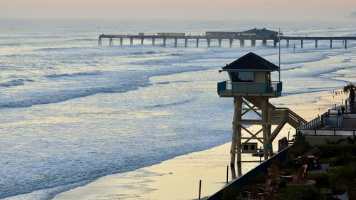 Lifeguard hut on beach against sky during winter