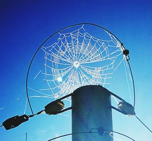 Low angle view of ferris wheel against blue sky