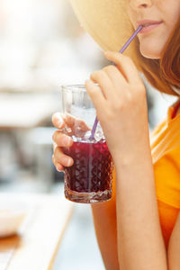 Midsection of woman drinking glass