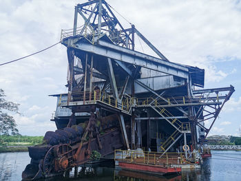 Low angle view of crane against sky